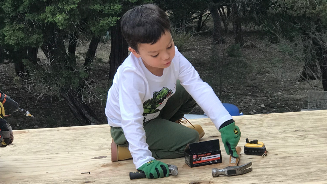 Isaiah sitting on top of the shed he is helping his grandpa build. He is pointing to and identifying his hammer. Isaiah sitting on top of the shed he is helping his grandpa build. He is pointing to and identifying his hammer.